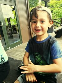 Portrait of smiling boy sitting outdoors