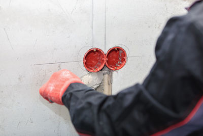 Low section of person holding red standing outdoors