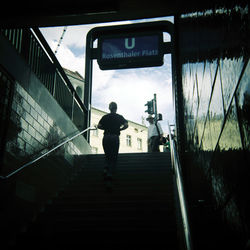 Rear view of man standing on staircase