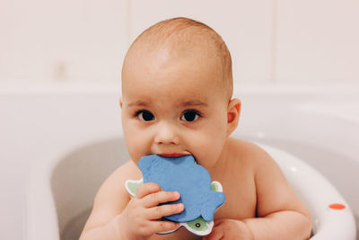 Sweet funny baby taking a bath. baby chewing a toy in a bath chair.