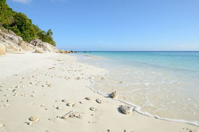 Scenic view of beach against clear blue sky