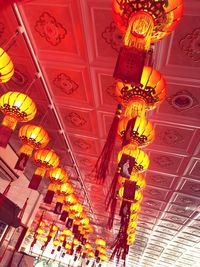 Low angle view of illuminated lanterns hanging in building at night