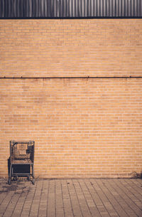 Abandoned shopping cart against brick wall