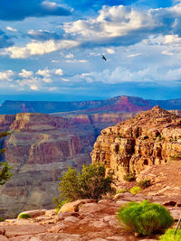 Rock formations on landscape against cloudy sky