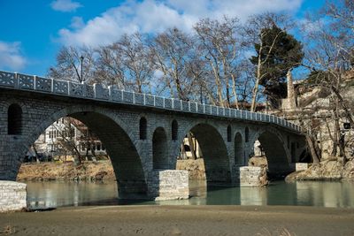 Arch bridge over river against sky