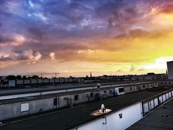 Silhouette of building against cloudy sky at sunset