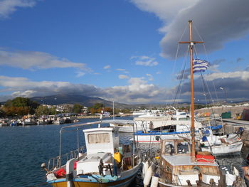 Sailboats moored at harbor against sky