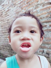 Close-up portrait of cute boy against wall