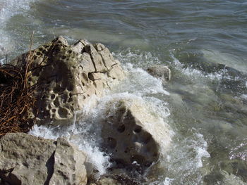 High angle view of waves breaking on rocks