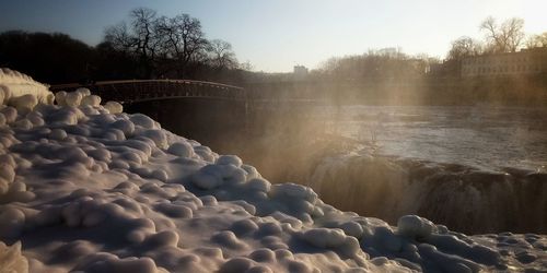 Scenic view of waterfall against sky during winter