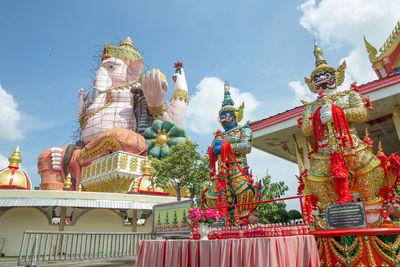 Perspective of lord ganesha and giant in wat pong agas temple with a large golden pagoda 