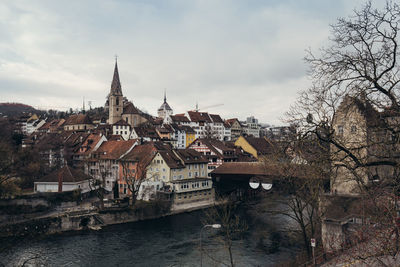 River amidst buildings in city against sky