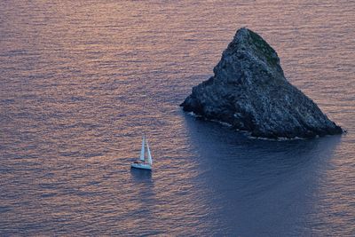 High angle view of rock formation amidst sea during sunset