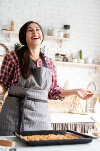 Laughing woman preparing food at home