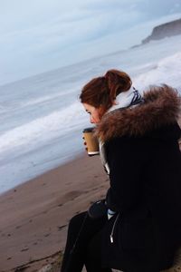 Woman having coffee at beach