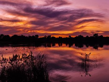 Scenic view of lake against romantic sky at sunset