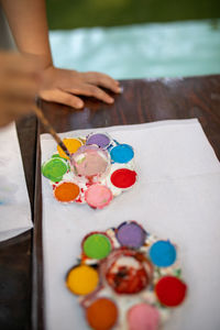 Cropped hands of child painting on book