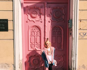 Woman standing by door of building