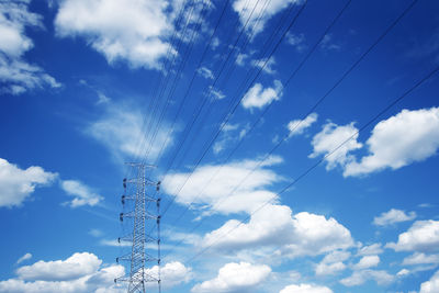 Low angle view of electricity pylon against blue sky