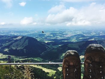 Low section of man on mountain against sky