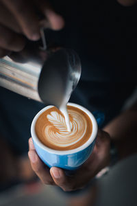 Midsection of man preparing coffee in cafe