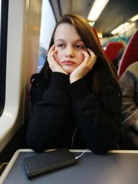 Portrait of young woman sitting in train