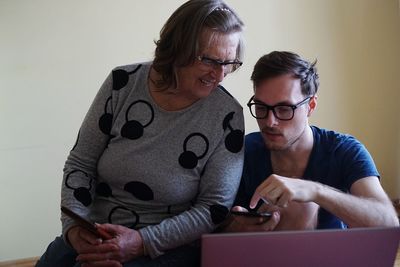 Young woman looking away while sitting on smart phone