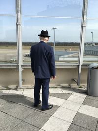 Rear view of man standing on street against sky