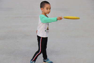 Boy playing with plastic disc at park