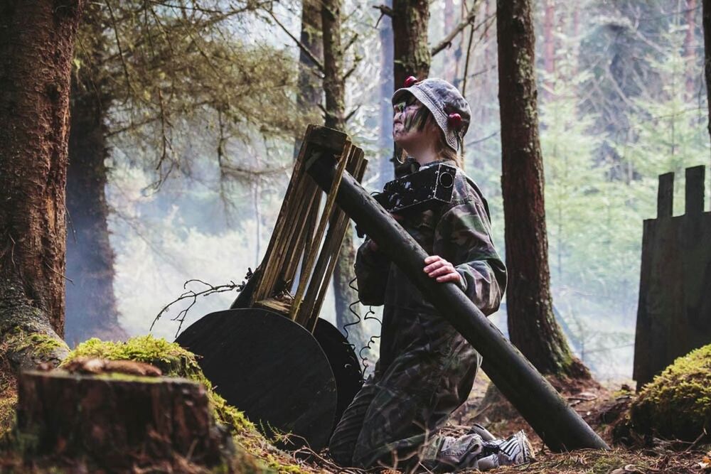 WOMAN SITTING ON TREE IN FOREST