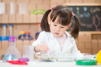 Young girl play science experiments for homeschooling