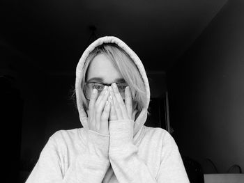 Portrait of young woman wearing hooded shirt at home