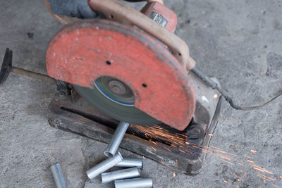 Low section of person with high angle view of human hand holding metal