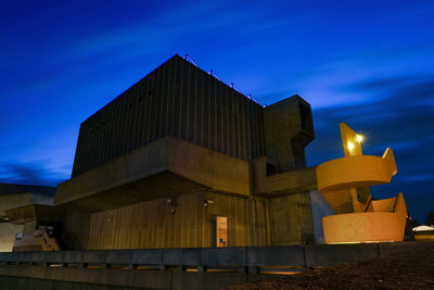 Low angle view of illuminated building against sky at dusk