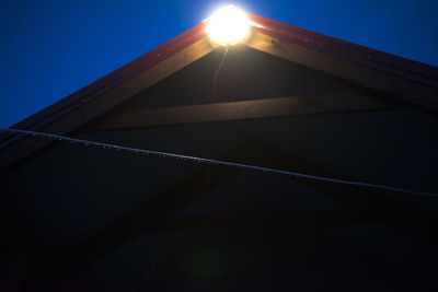Low angle view of illuminated built structure against blue sky