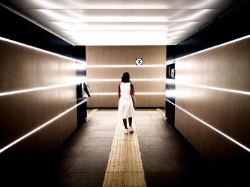 Rear view of woman walking in subway