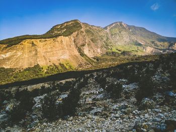 Scenic view of mountains against blue sky