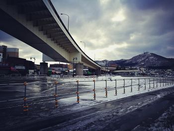 Bridge over snow covered city against sky