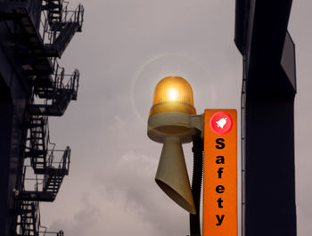 Low angle view of illuminated sign against sky