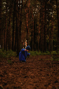 Rear view of woman standing in forest