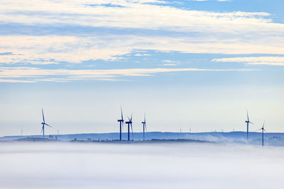 Wind turbines above the mist in a rolling landscape