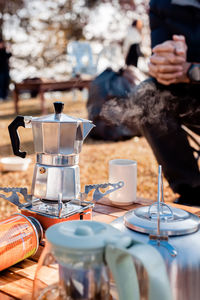Man preparing coffee in a moka pot outdoor.