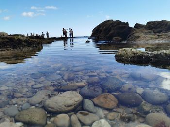 Rocks on beach against sky