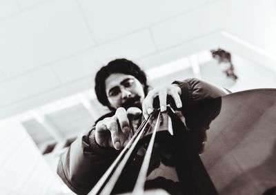 Low angle view portrait of young man playing musical instrument