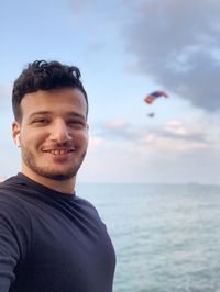 Portrait of young man against sea against sky