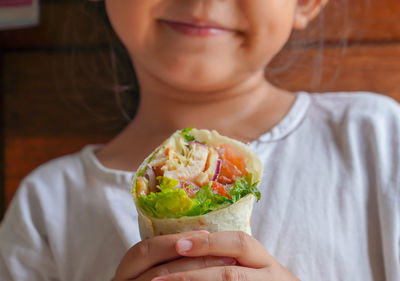 Close-up of woman holding wrap kebab
