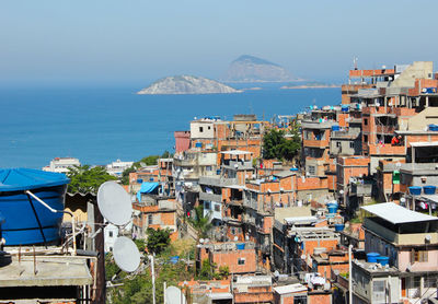 High angle view of town by sea against sky