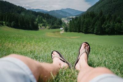 Low section of woman sitting on grassy field