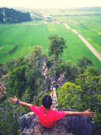 Rear view of woman with umbrella on landscape