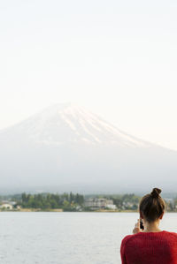 Rear view of woman on mountain against clear sky